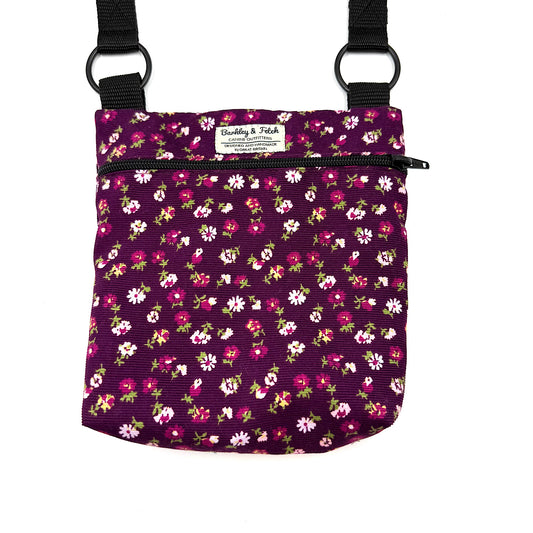 Floral-patterned bag with black straps on a white background