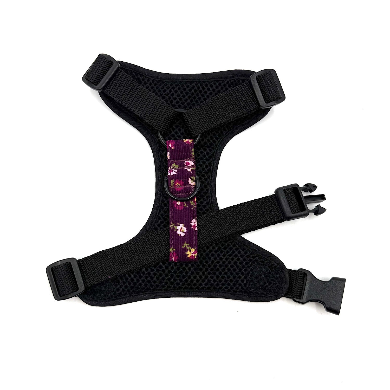 Black dog harness with floral pattern on a white background