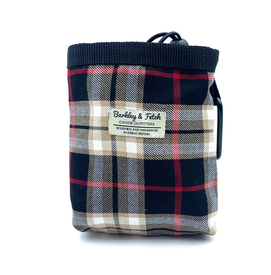 A black beige tartan dog treat bag with an elastic drawcord closure and a brand label shown on the front.