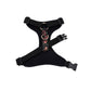 Black dog harness with floral pattern on a white background