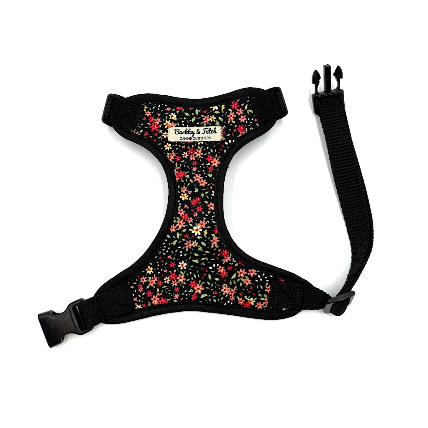Floral-patterned dog harness with black straps on a white background