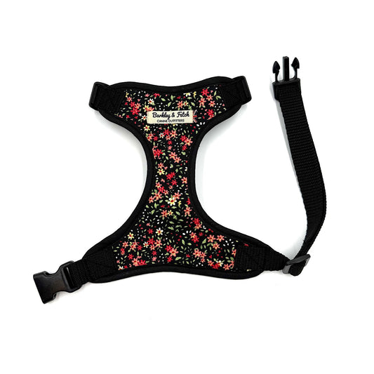 Floral-patterned dog harness with black straps on a white background