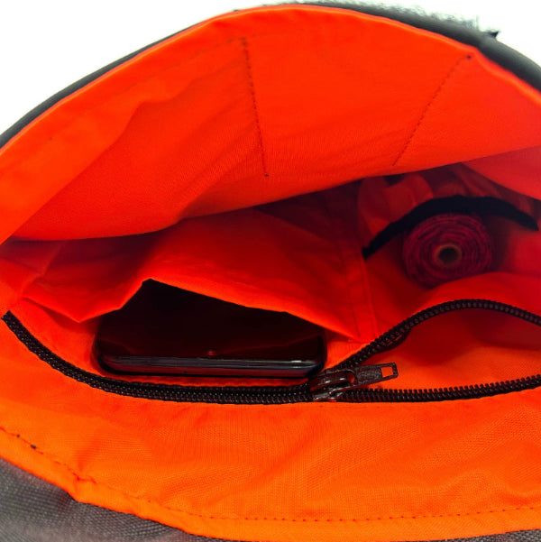 Close-up of a black bag with an open orange compartment revealing a phone inside- British handmade by Barkley and Fetch