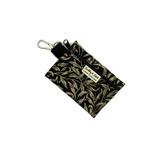 Small pouch with gold leaf pattern and key ring on a white background