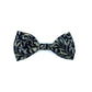 A dog bowtie with a black willow print, featuring a leaf pattern, on a navy background.