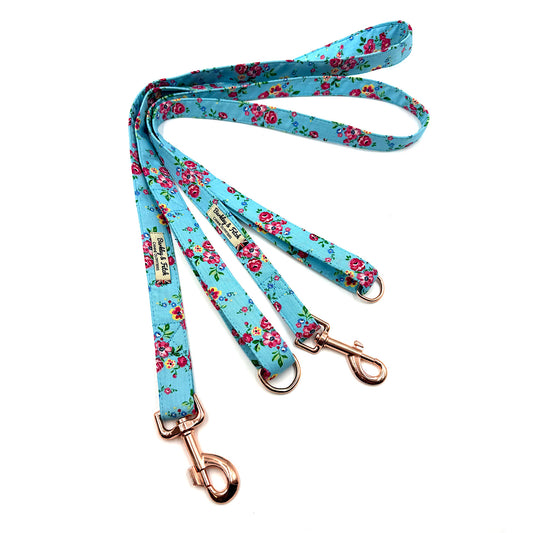 Floral-patterned dog leash with rose gold hardware on a white background