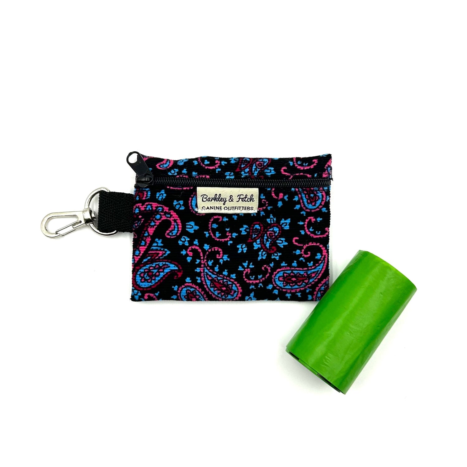 Small black and pink paisley patterned pouch with a green tube on a white background