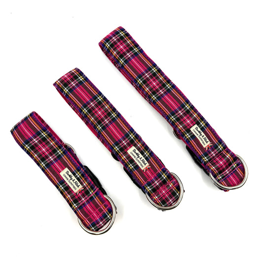 Three plaid dog collars with metal buckles on a white background