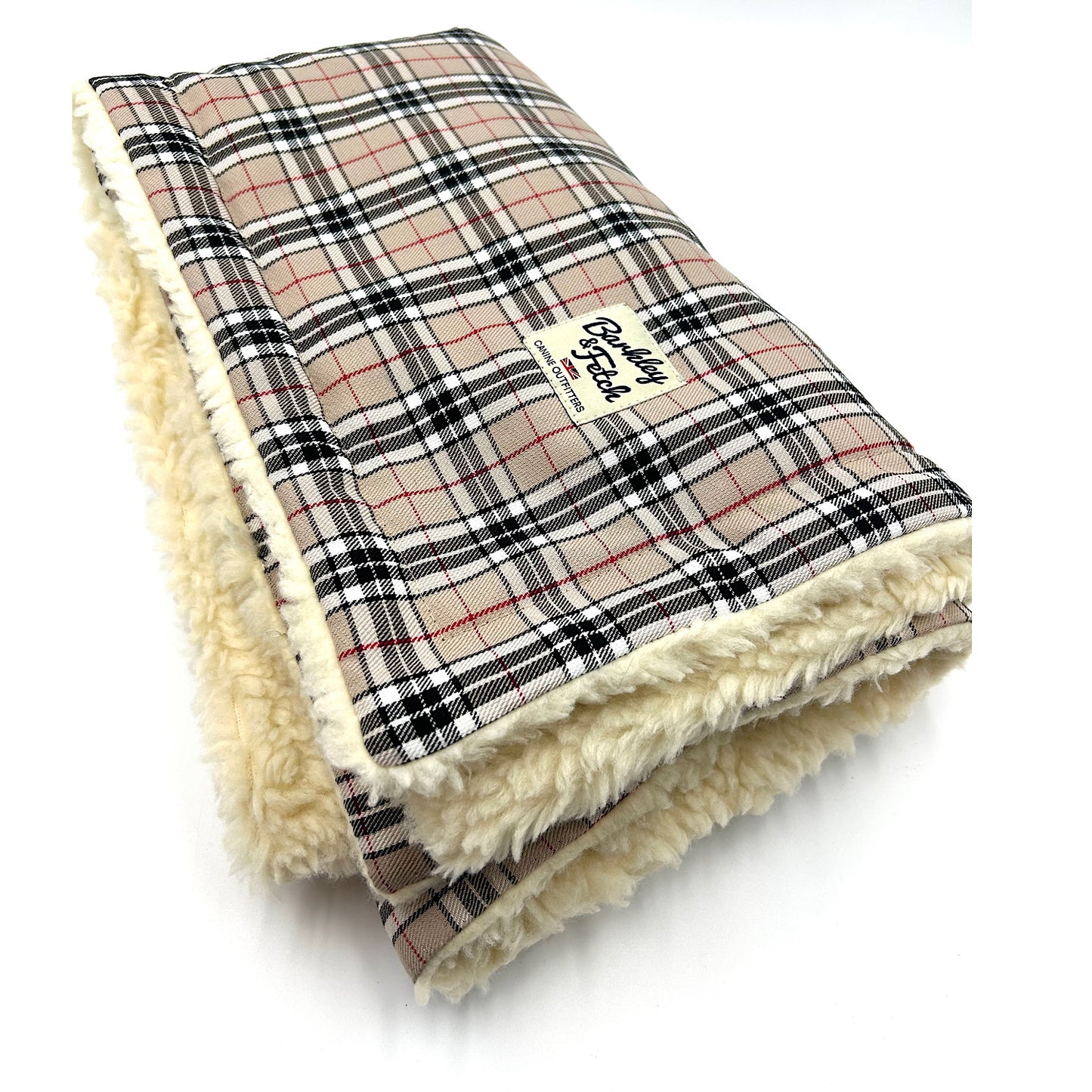 A caramel tartan dog blanket with a plush cream edge, displaying the brand label 'Barkley & Fetch'. handmade by Barkley and Fetch of Great Britain