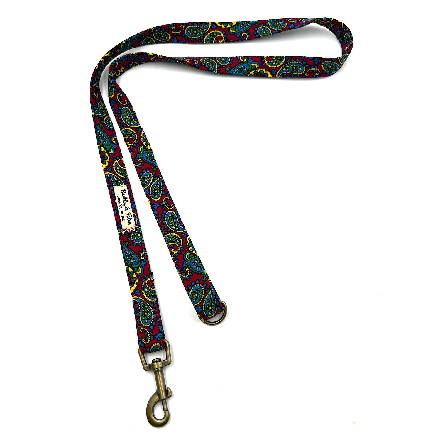 Colorful patterned dog leash with brass clip on a white background