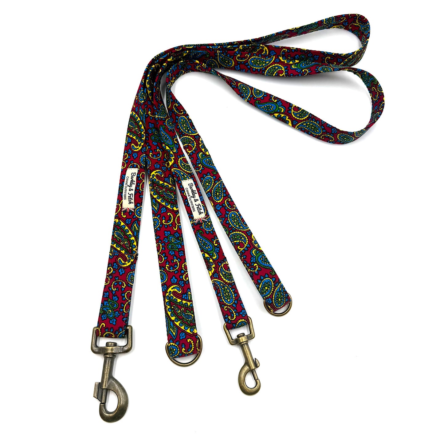 Colorful paisley patterned dog leash with brass clips on a white background