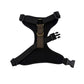 A black mesh dog harness with a brown and beige plaid center strap, a brass ring, and black plastic quick-release buckles, shown on a plain white background. Handmade in Great Britain by Barkley and Fetch.