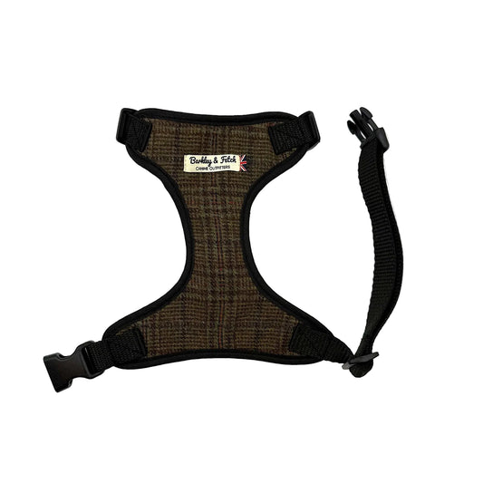 A brown and black plaid dog harness with black nylon trim, adjustable plastic buckles, and a matching black leash attachment strap, shown on a plain white background. Handmade in Great Britain by Barkley and Fetch.