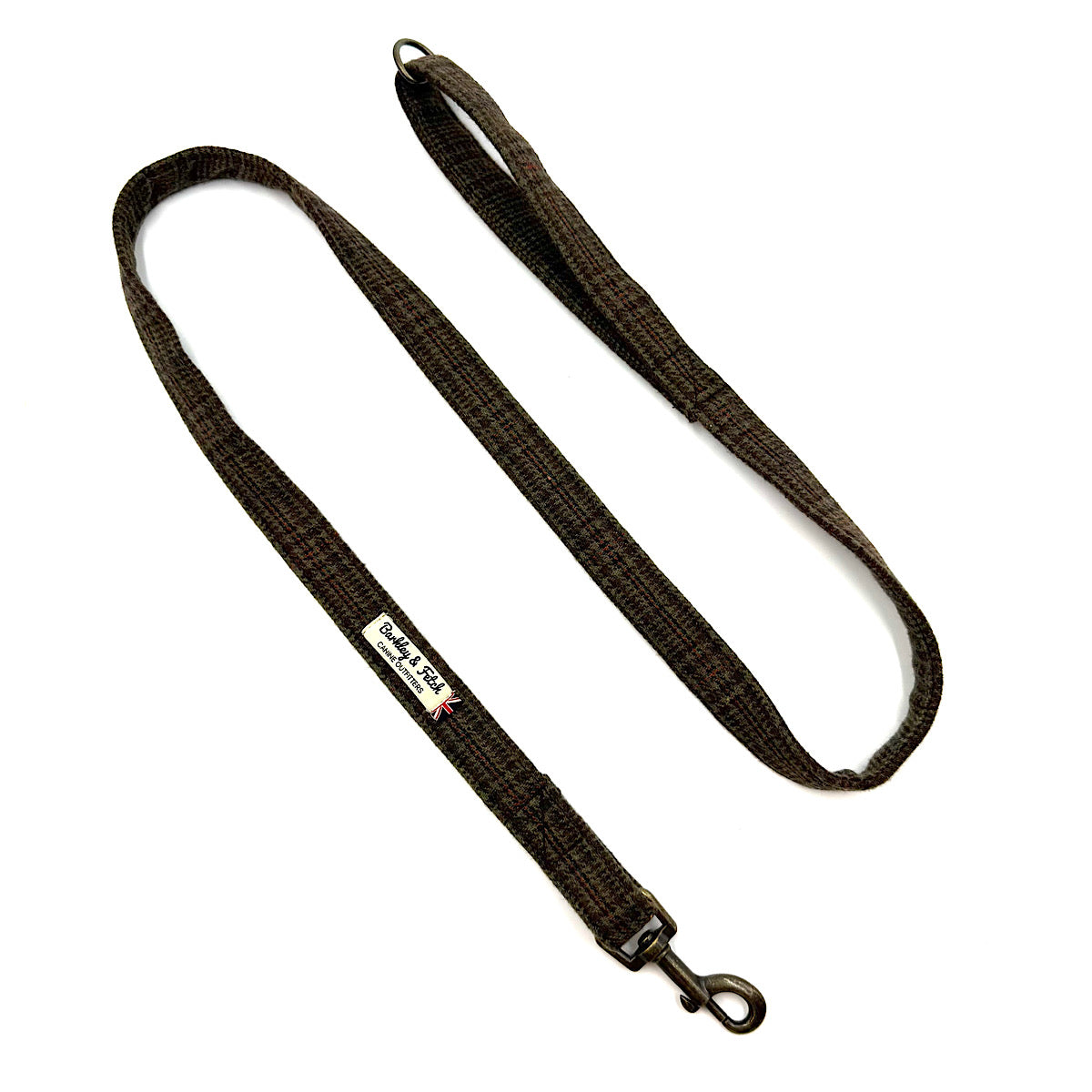 A dark brown woven dog leash with a metal snap hook and a small white brand label, shown on a plain white background. Handmade in Great Britain by Barkley and Fetch.