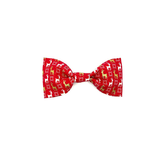 A red dog bowtie with a white and gold reindeer print, designed to slip over a matching collar. handmade in uk by Barkley and Fetch