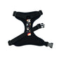 Black dog harness with colorful skull pattern on a white background