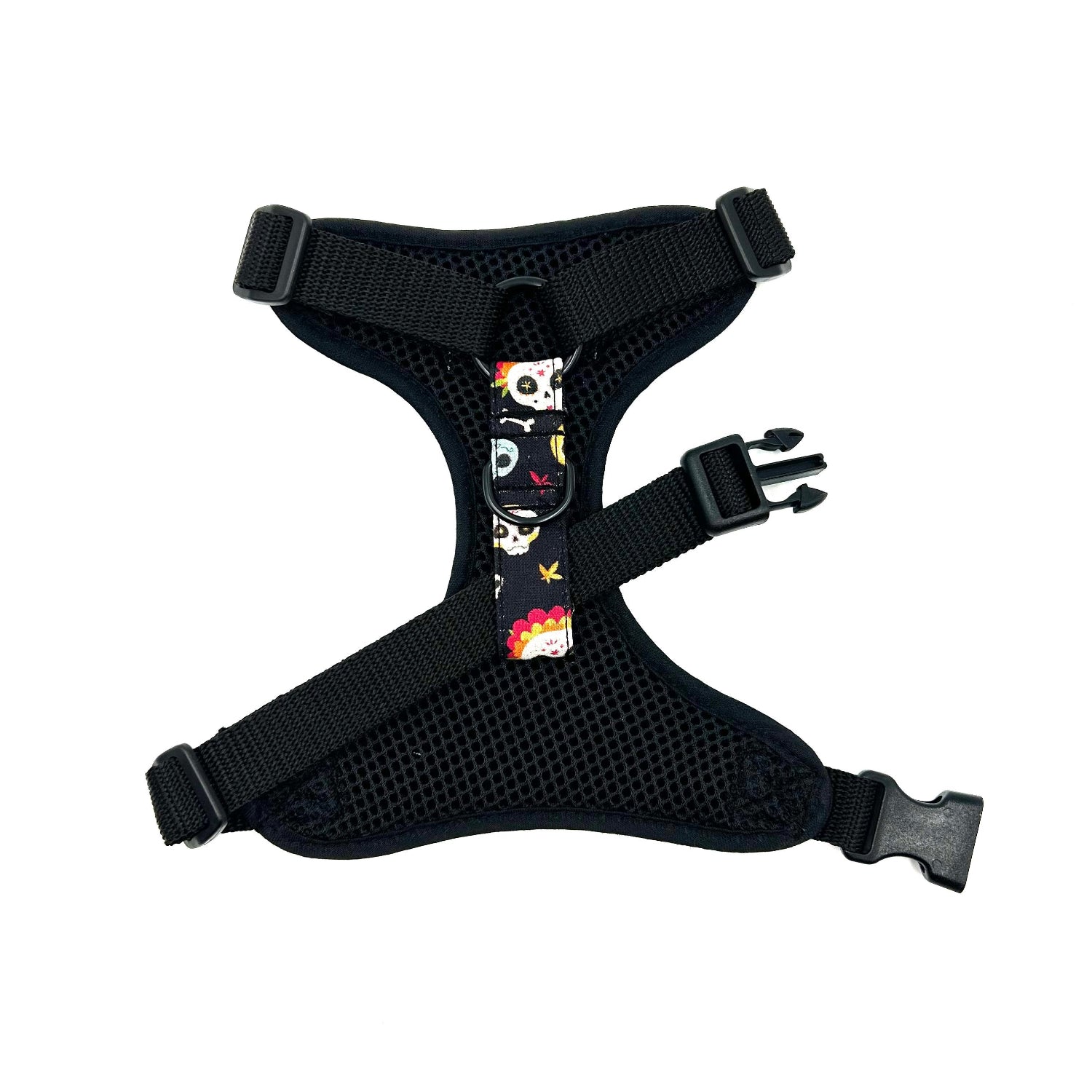Black dog harness with colorful skull pattern on a white background