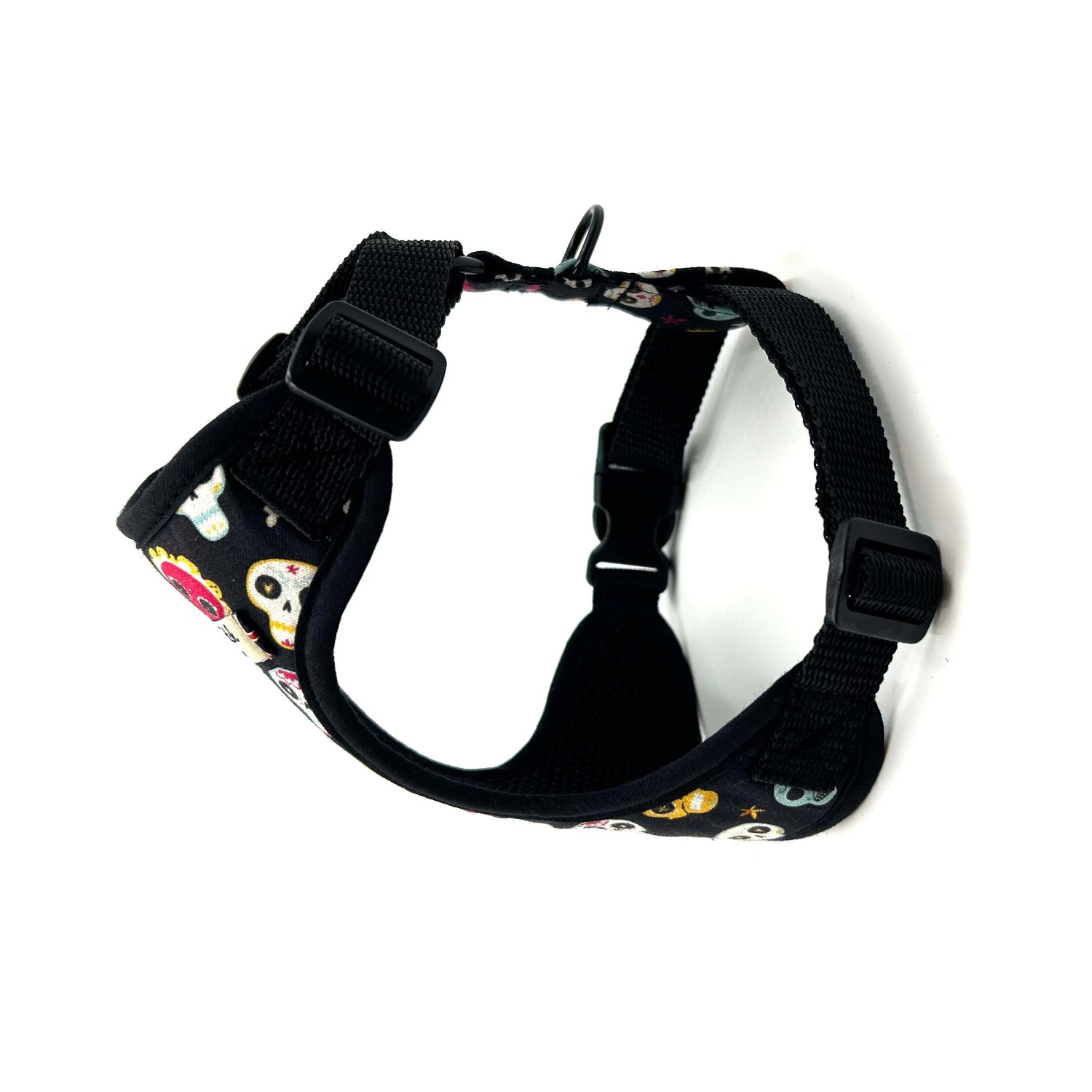 Black dog harness with colorful skull pattern on a white background