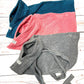 Three folded dog towels in blue, pink, and gray on a wooden surface. Handmade by Barkley and Fetch on our UK workshop