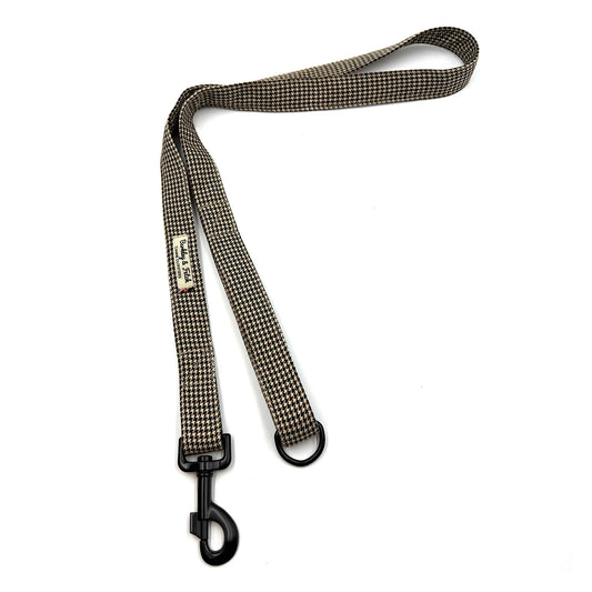 Dog leash with checkered pattern and black clip on a white background