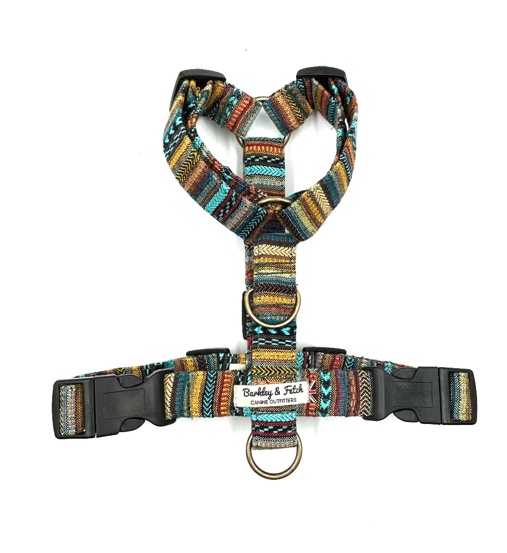 A striped multicolor dog harness with adjustable straps and side release buckles.