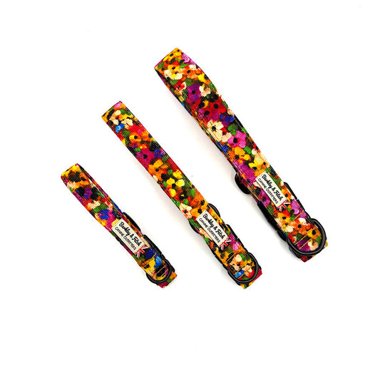 Three colorful floral-patterned dog collars on a white background