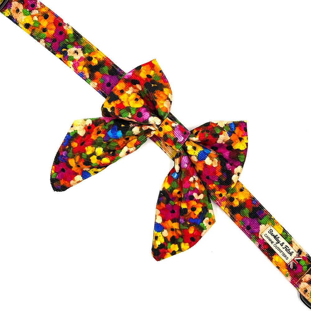 Colorful floral-patterned bow tie with a brand label on a white background handmade by Barkley And Fetch