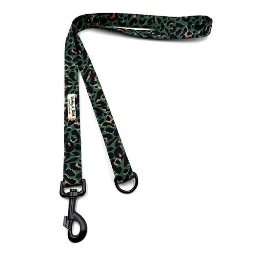 Leopard print dog leash with black clip on a white background