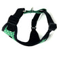 Green and black dog harness with polka dot pattern on a white background