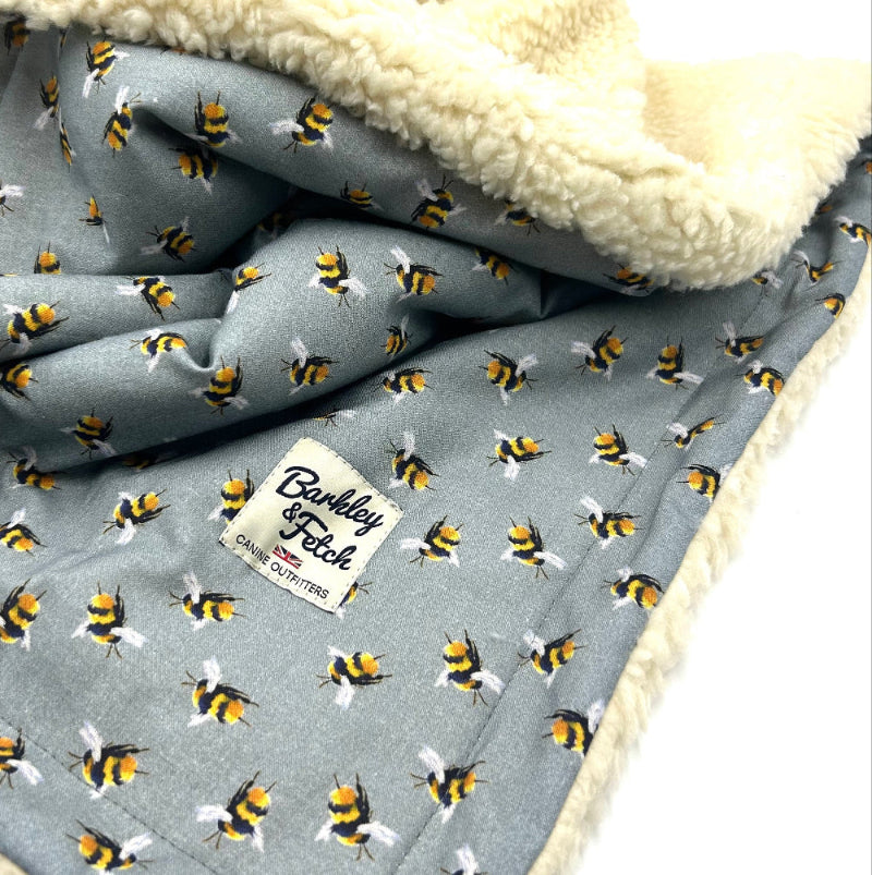 Grey blanket with bee pattern and white label, featuring 'Barkley & Fetch' brand.