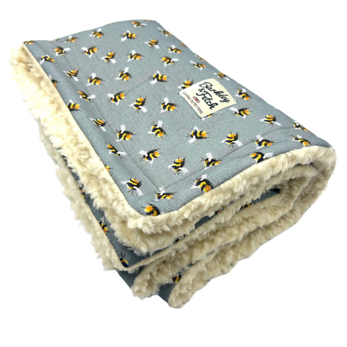 A grey dog blanket with a bee print design, featuring a plush fleece-like texture on the inside handmade by barkley and fetch uk