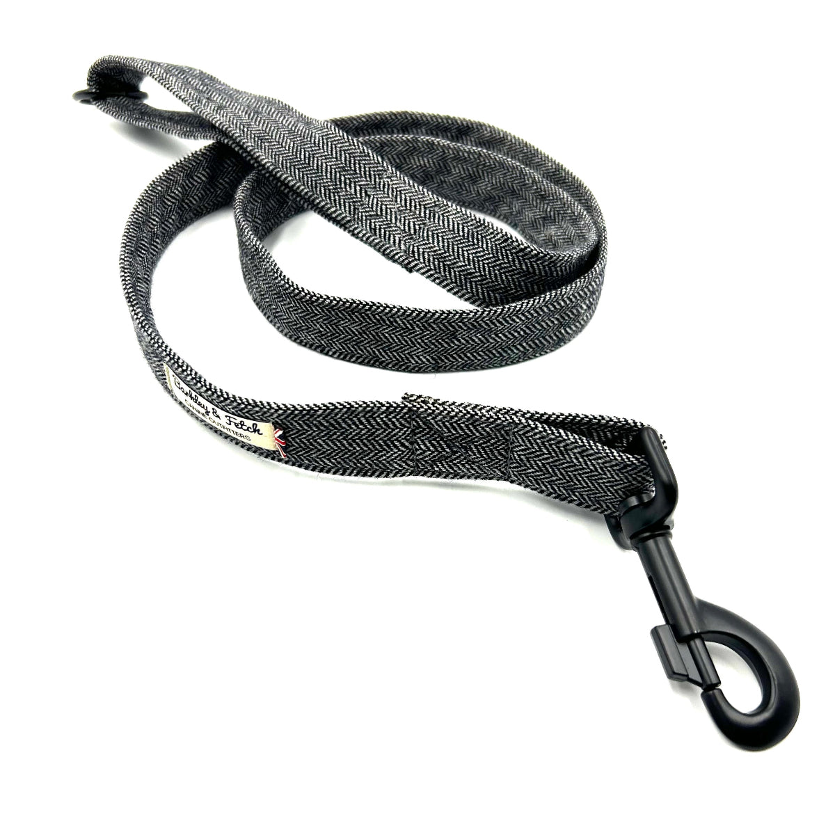 A grey herringbone pattern dog lead with a metal trigger hook and a D-ring on the handle.