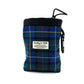 A plaid treat bag with blue, green, and yellow patterns, featuring a black drawcord and label with 'Barkley & Fetch' written on it.