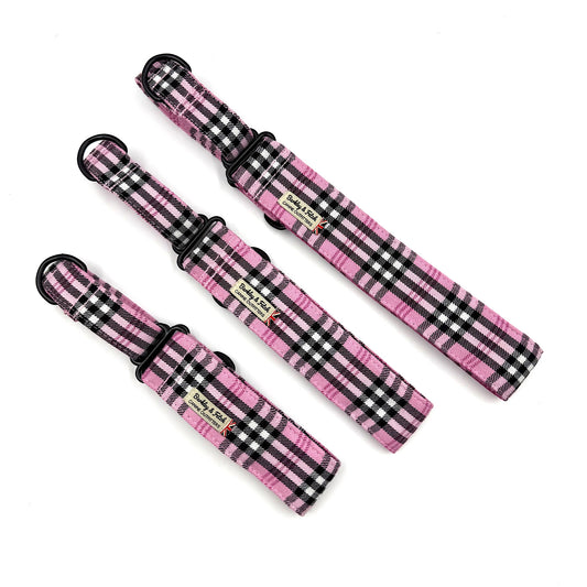 three pink and black checkered dog collars on a white background