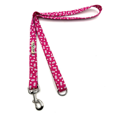 Pink dog leash with white floral pattern on a white background