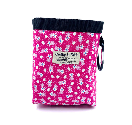 Pink floral-patterned pouch with a visible brand label on a white background