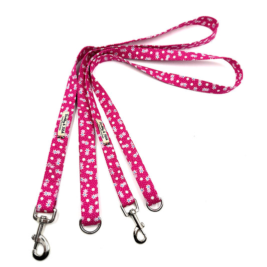 Pink dog leash with white floral pattern on a white background