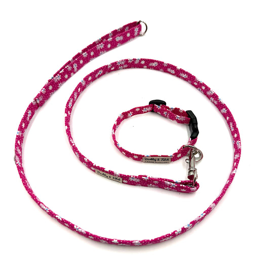 Pink floral-patterned dog leash and collar set on a white background