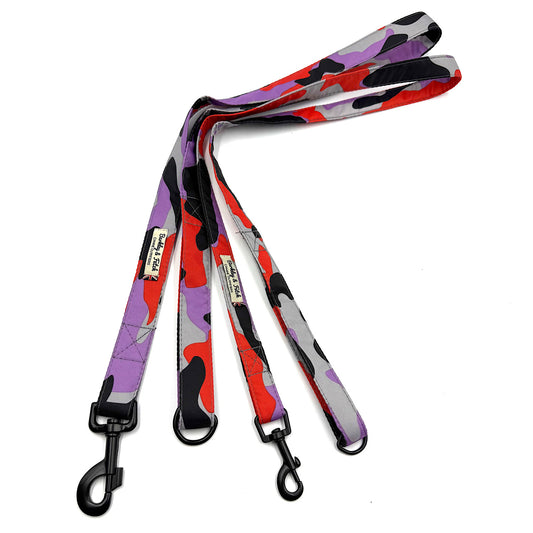 Colorful camouflage-patterned dog leash with black clip on a white background