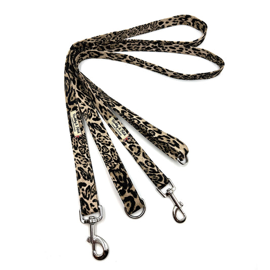 Leopard print dog leash with metal clips on a white background