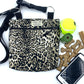 Leopard print bag with pet accessories including a tennis ball, treats, and a phone on a white background handmade in the UK by Barkley and Fetch