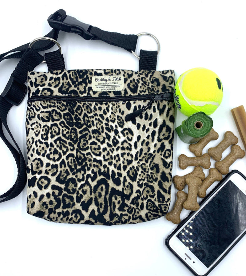 Leopard print bag with pet accessories including a tennis ball, treats, and a phone on a white background handmade in the UK by Barkley and Fetch