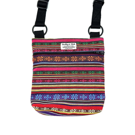 Multicolored striped pouch with black straps on a white background