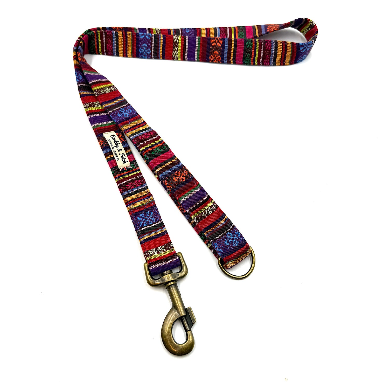 Colorful patterned dog leash with brass clip on a white background
