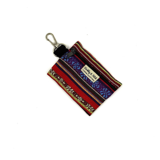 Colorful striped keychain pouch with a visible brand label on a white background