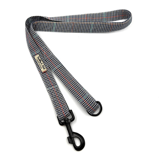 Checkered dog leash with a metal clip on a white background