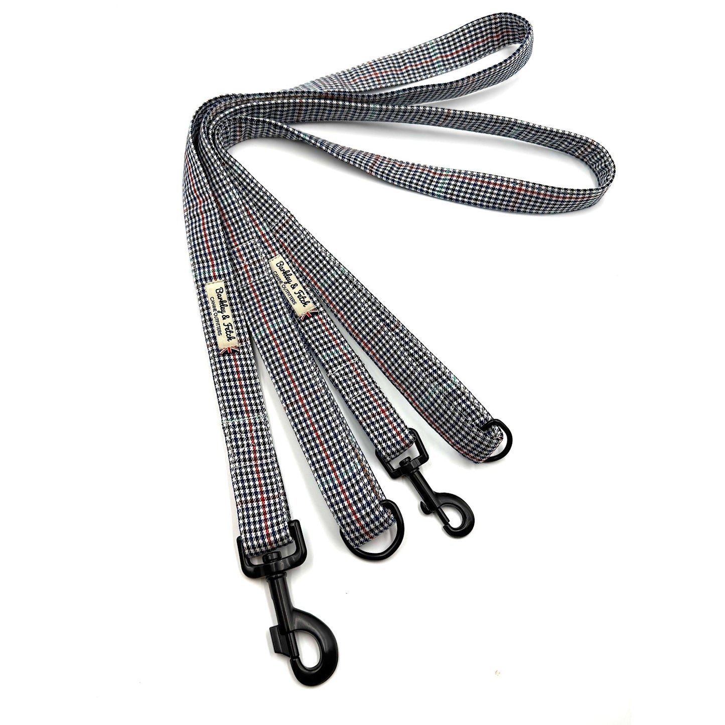 Houndstooth patterned dog leash with metal clip on a white background