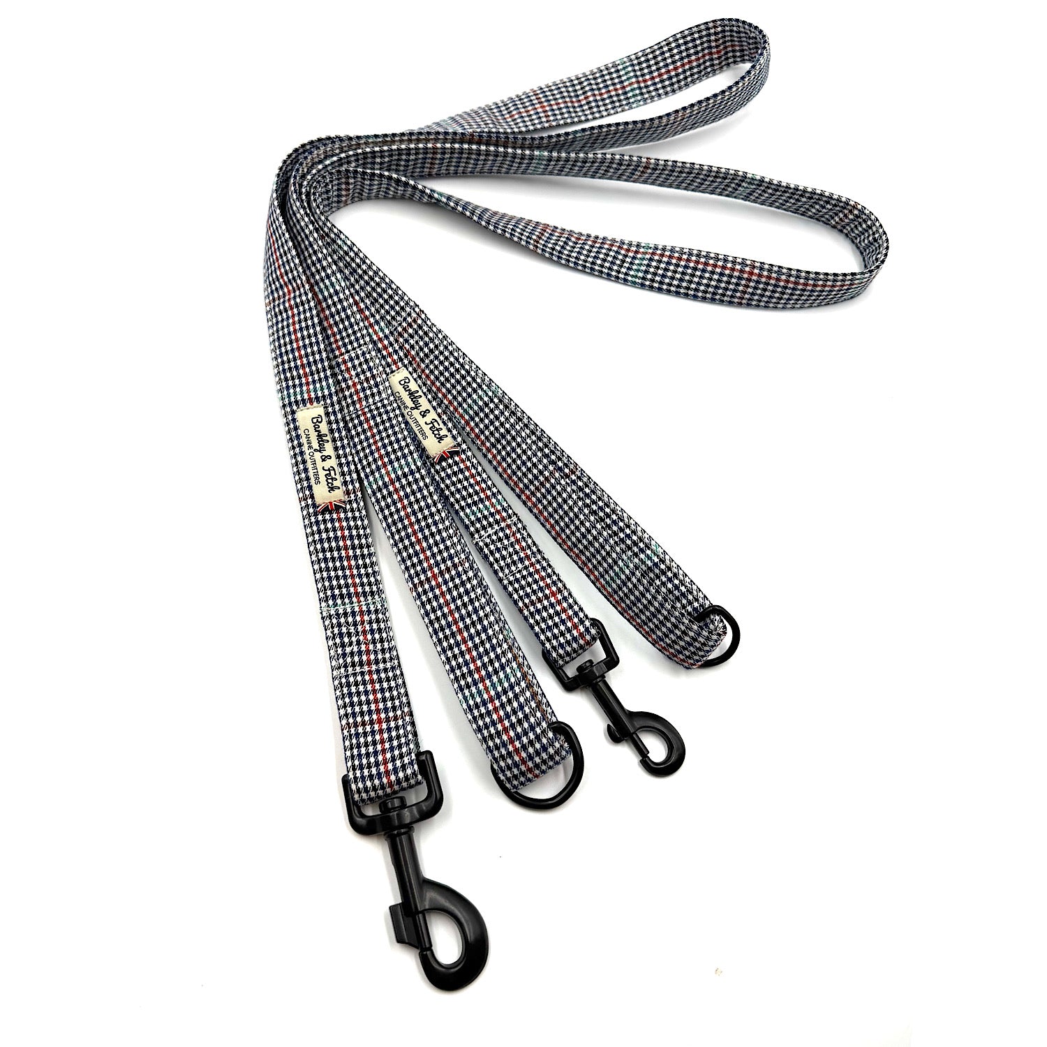 Houndstooth patterned dog leash with metal clip on a white background