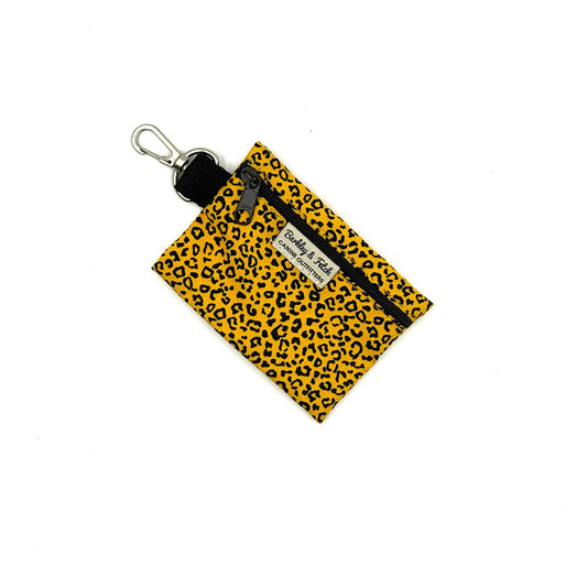 Yellow leopard print pouch with black zipper and keychain on a white background
