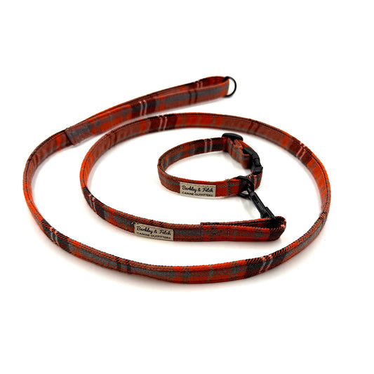orange and black plaid dog leash with a visible brand label on a white background